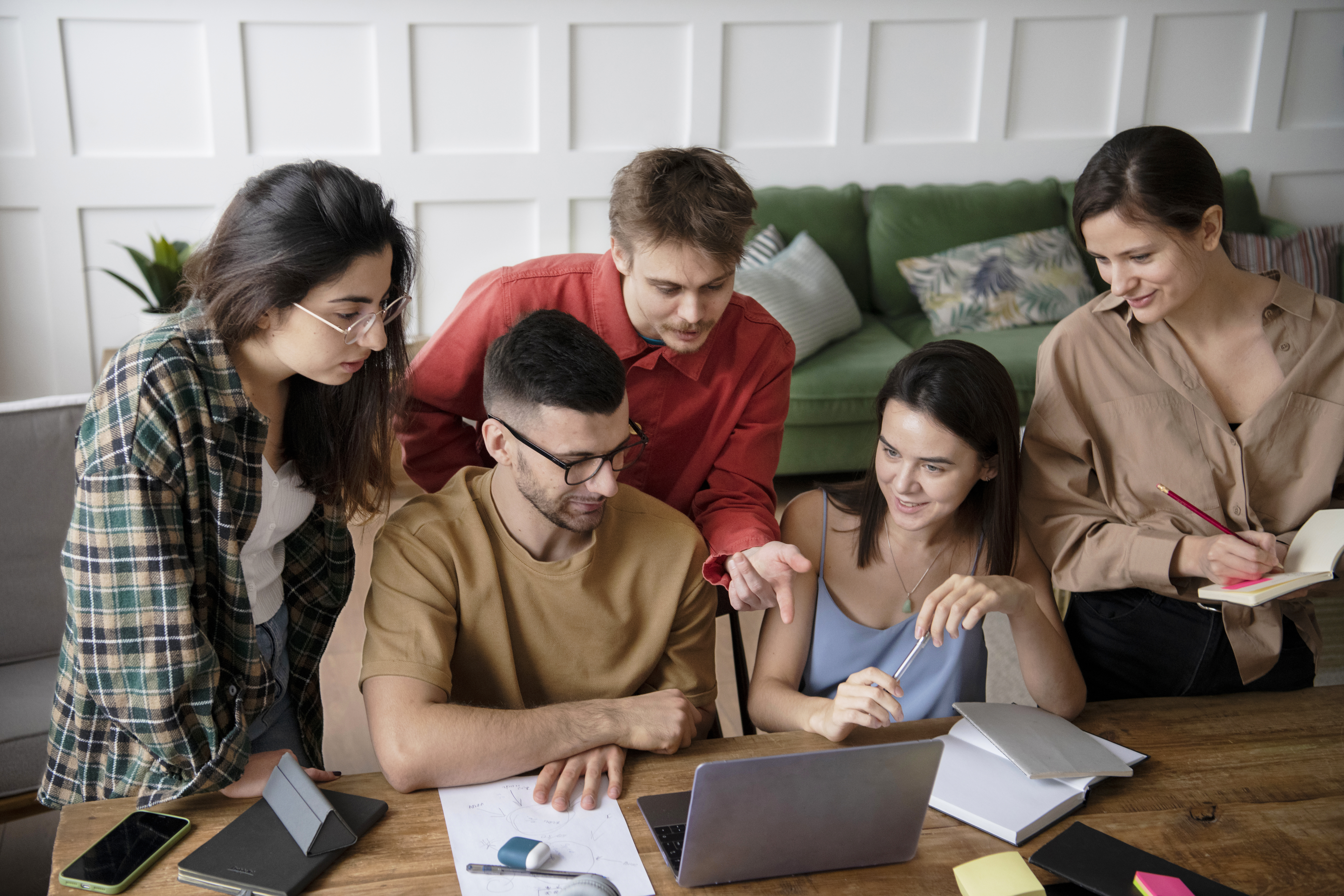 Students and freelancers collaborating around a laptop